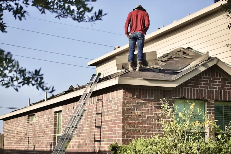 Professional roofer working on a residential roof in Millheim